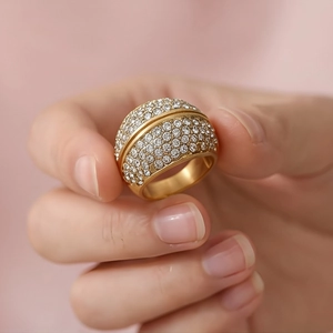 Macro detail of 18k gold plated dome ring featuring a pavé set crystal design and smooth band