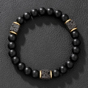 Detail of beaded bracelet featuring matte black beads with square volcanic lava stones