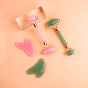 Detailed set of pink and green resin face rollers with matching heart jade scrapers