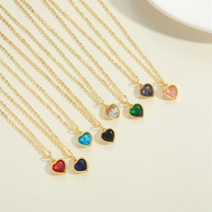 Macro shot of colorful heart-shaped zircon pendants on golden chain necklaces