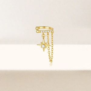 Macro detail of gold-plated silver ear cuff with sparkling star pendant and delicate tassels