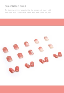 Detail of pink gradient press-on nails with 3D white flowers and pearl embellishments