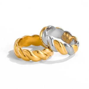 Detail shot of twisted cable design rings in gold and two-tone silver stainless steel