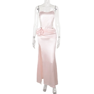 Detailed view of pink satin dress featuring a 3D floral accent and high side slit