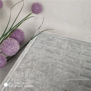 Close-up of grey velvet jewelry display tray with quilted grid pattern and soft texture