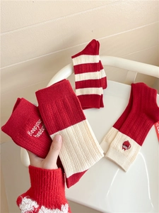 Detailed view of red knitted wool socks with striped patterns and embroidery details