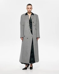 Détail d'un manteau long en laine grise avec col contrasté sombre et boutons à double boutonnage