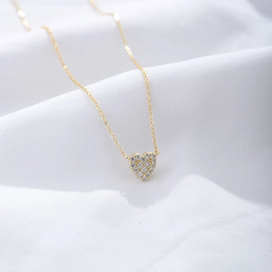 Close-up of a gold S925 silver heart necklace paved with sparkling zircon stones