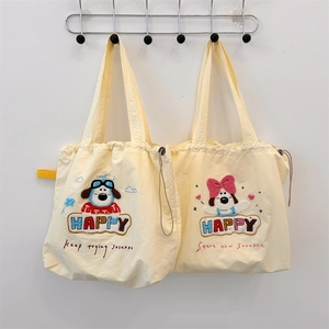 Detail of cute puppy embroidery and colorful HAPPY lettering on beige canvas tote bags
