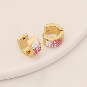 Détail de boucles d'oreilles en C dorées avec strass dégradés roses et blancs élégants