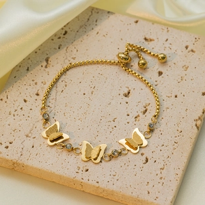 Adjustable gold butterfly charm bracelet with sparkling rhinestones on textured stone