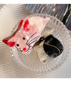 Detail of pink mouse acetate hair claw clip with shell texture in glass bowl
