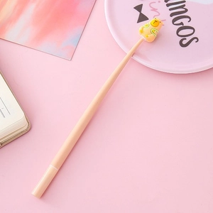 Creative pink gel pen with yellow alpaca charm on a minimalist pink stationery background