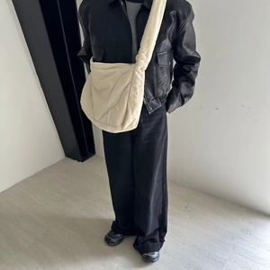 Beige oversized puffer tote bag styled with a black leather jacket and trousers