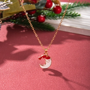 Detail of Christmas necklace with Santa on moon pendant over red festive background