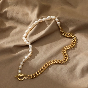 Detail of baroque pearl and 14k gold plated cuban link necklace with toggle clasp