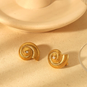Macro detail of gold conch shell stud earrings with sparkling cubic zirconia inlay