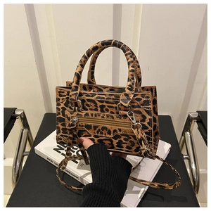 Dettaglio borsa leopardata con trama in pelle e tasca con zip in metallo sopra i libri