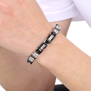 Detail of two-tone stainless steel punk chain bracelet with black rubber accents on wrist