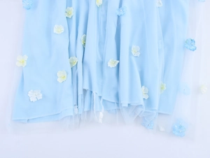 Detail of 3D flowers with pearls on light blue mesh fabric for a summer vacation dress