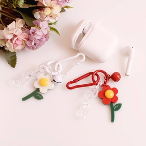 Detail of red and white flower pendants with resin charms, bells and colored chains
