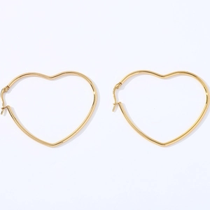 Detailed view of large gold heart-shaped hoop earrings in polished stainless steel