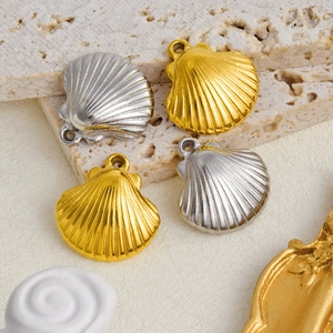 Macro detail of gold and silver stainless steel shell pendants on textured stone surface