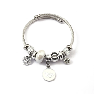 Silver charm bangle featuring tree of life and butterfly pendants on woven steel cord