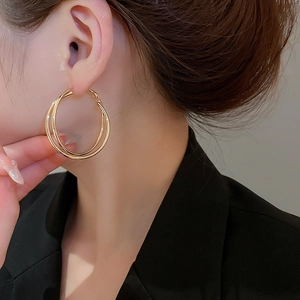 Detailansicht doppellagiger goldener Creolen am Model in professionellem Studio-Set