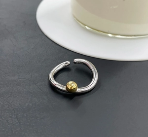 Detailed view of S925 sterling silver twisted ring with a distinct golden ball accent