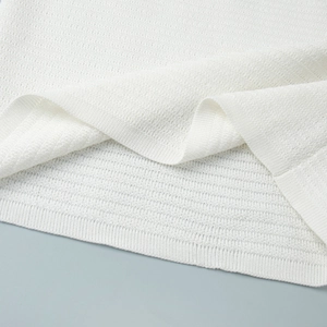 Close-up of white ribbed knit fabric texture showing fine horizontal weaving patterns