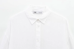 Close-up of white cotton linen shirt showing premium texture and standard square collar