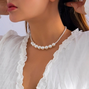 Detail of graduated white faux pearls showing high luster and elegant layering effect