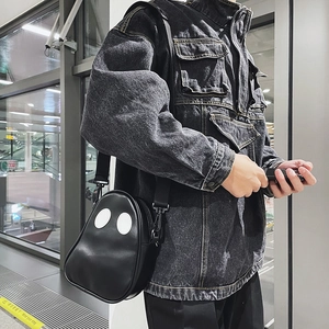 Detail of creative ghost-shaped black crossbody bag with adjustable nylon strap on model