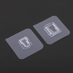 Close-up of two transparent adhesive wall hooks for drill-free shelf mounting