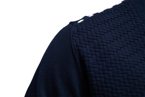 Macro view of navy blue knit cardigan shoulder with complex 3D textured jacquard pattern
