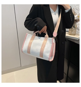 Lifestyle view of a large canvas tote bag in white and pink for daily commuting use