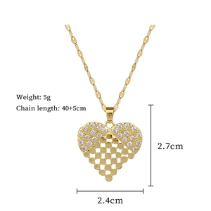 Detail view of gold heart pendant with cubic zirconia and hollow grid design