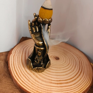 Macro detail of solid brass backflow incense burner featuring buddha hand and lotus design
