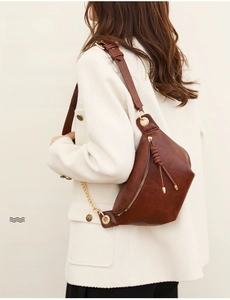 Nahaufnahme braune Vintage Satteltasche aus Leder mit geflochtenem Quasten-Reißverschluss