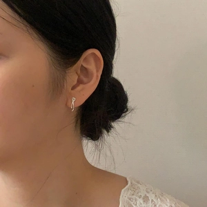 Close-up of minimalist 925 sterling silver bow knot stud earrings worn by a model
