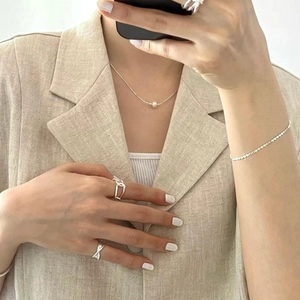 Close-up of minimalist 925 sterling silver necklace with pearl and matching silver jewelry