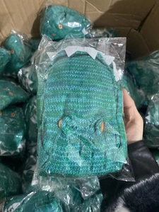 Detailed close-up of green knitted crocodile socks with decorative button eyes and teeth