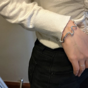 Minimalist S925 sterling silver bangle with irregular wavy texture on a female wrist