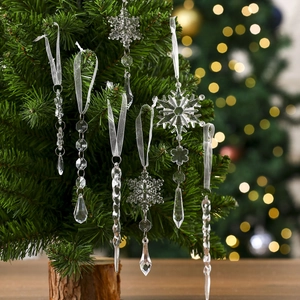 Close-up of clear acrylic snowflakes and icicles hanging on a glowing Christmas tree