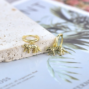 Detailed macro view of gold leopard hoop earrings with black spotted texture finish