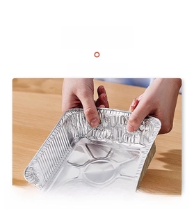 Detail showing hands testing the thick and durable food-grade aluminum foil tray