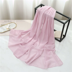 Detailed view of light pink chiffon scarf with elegant drape on geometric metal stand