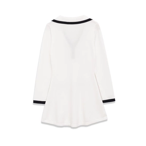 Detail view of the back of a white knit dress with black contrast trim and long sleeves
