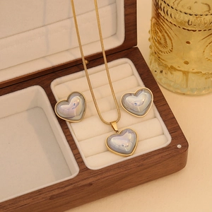 Détail d'un ensemble collier et boucles d'oreilles cœur dans un élégant coffret en bois